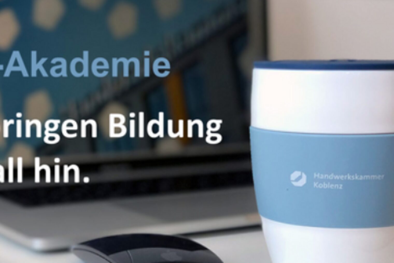 aufgeklappter Laptop und Kaffeebecher