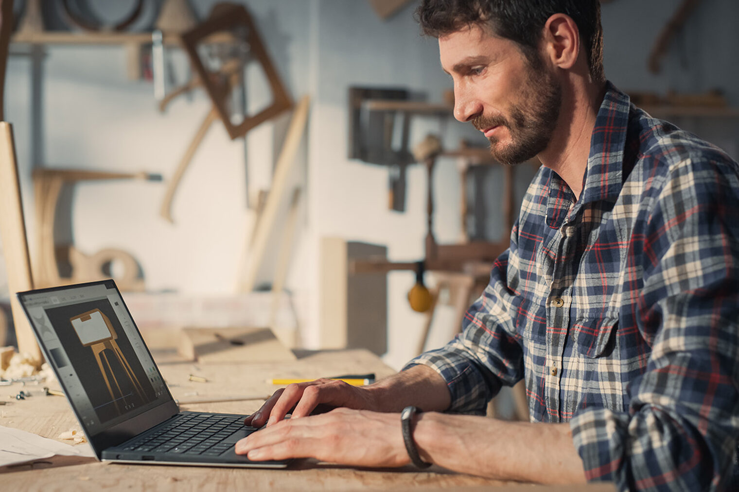 Mann am Laptop in einer Werkstatt Mann am Laptop in einer Werkstatt