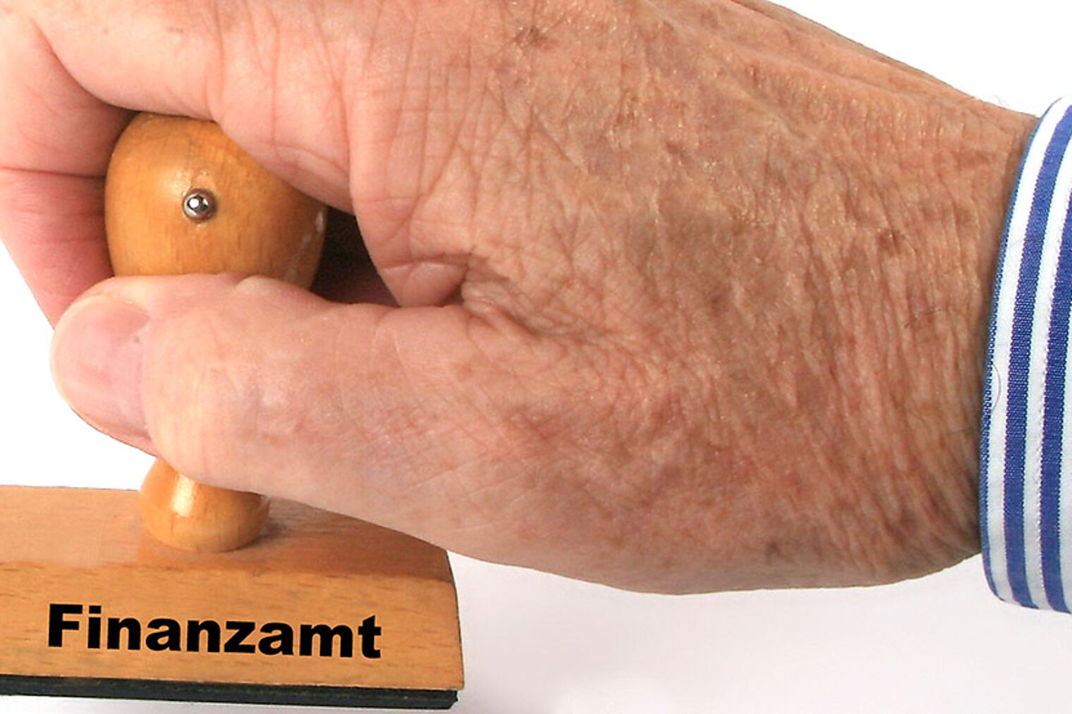 Eine Hand hält einen Stempel mit Aufdruck "Finanzamt". Eine Hand hält einen Stempel mit Aufdruck "Finanzamt".