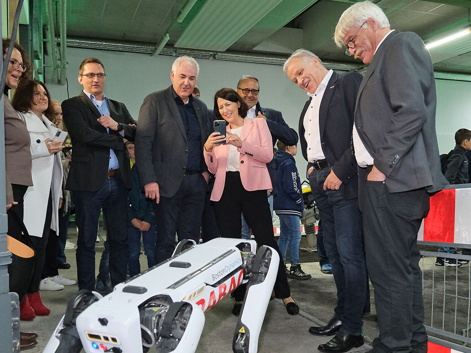 Wirtschaftsministerin Daniela Schmitt und weitere Besucher beobachten Roboterhund Spot.