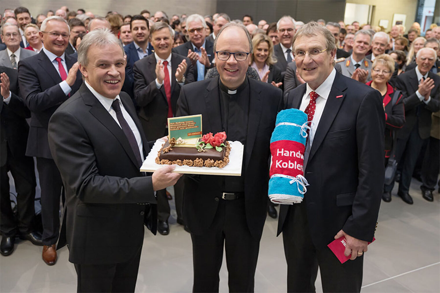 Bischof Stephan Ackermann erhält eine Torte mit dem Slogan der Imagekampagne des Handwerk.